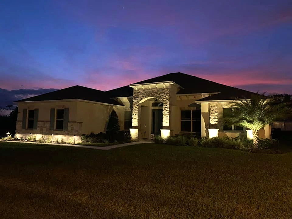 Central Florida home at dusk with architectural and landscape lighting installed